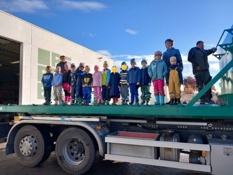 die Froschkinder stehen zum Gruppenfoto auf einem großen LKW