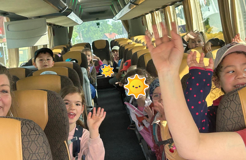 die Kinder sitzen im Bus und freuen sich auf ihre Fahrt
