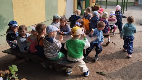 die Kinder sitzen am Tisch und essen Eis
