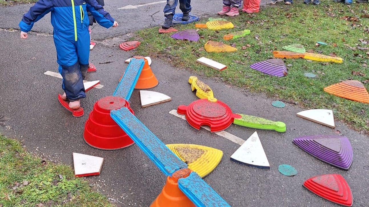 die Kinder balancieren über verschiedene Hindernisse